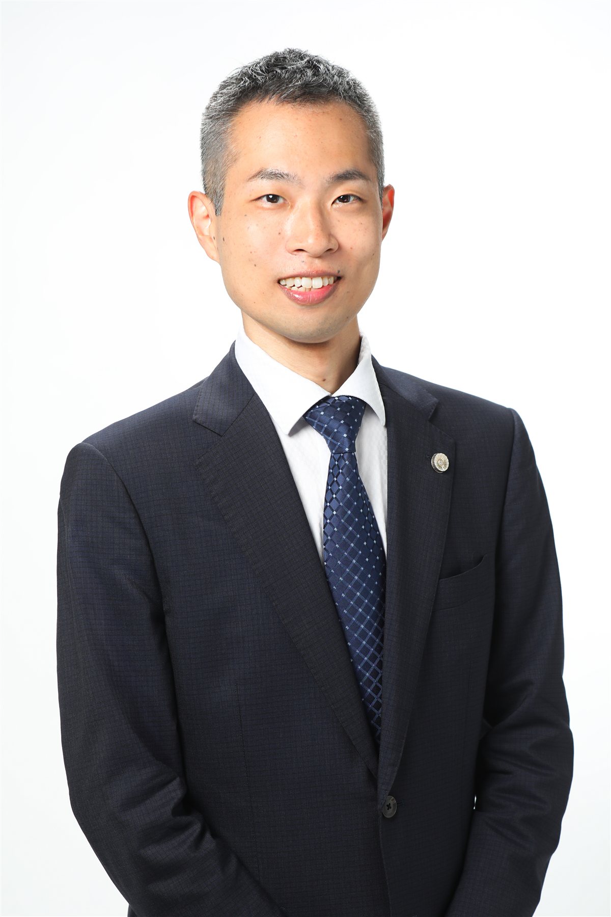 正装で微笑む塚井一将さん